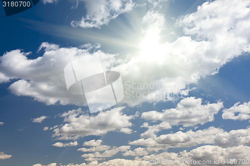 Image of Deep Blue Sky and Puffy Clouds With Sun Rays