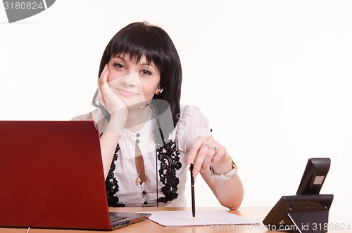Image of Call-center employee at a desk with pen in hand