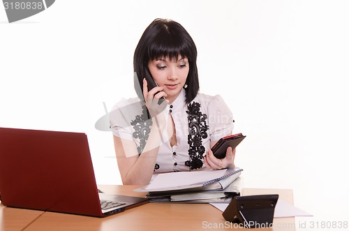 Image of Call-center worker talking on phone and looking at the other