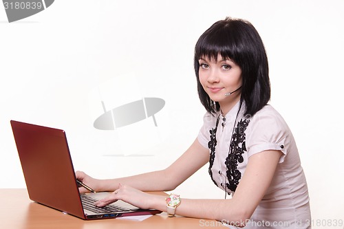 Image of Call-center employee at a table with laptop