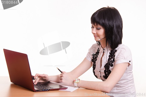 Image of Call-center employee at a desk working on laptop