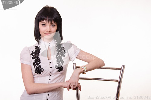 Image of Half-length portrait of beautiful girl in a white blouse with back chair