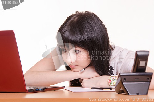 Image of Tired call-center employee looking at the monitor