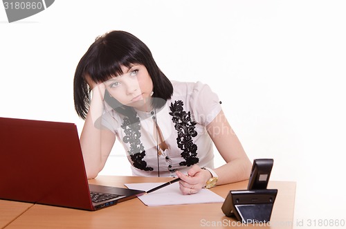 Image of Call-center worker wondered front of monitor, leaned her head on