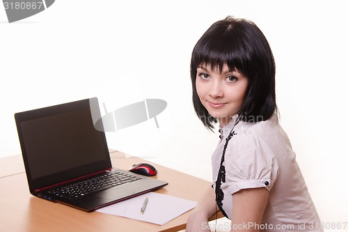 Image of The girl at the table with a laptop