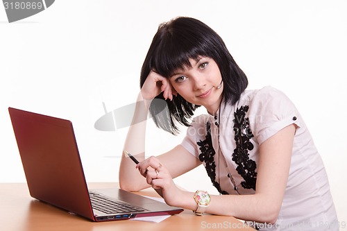 Image of Call-center employee at desk rests his head on 