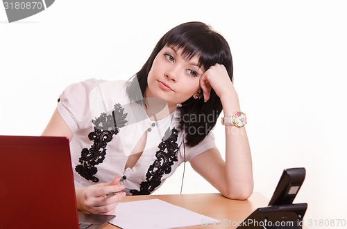 Image of Thoughtful call-center employee leaned her head on