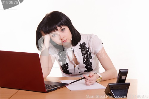 Image of Tired worker call-center front of monitor, leaned her head on