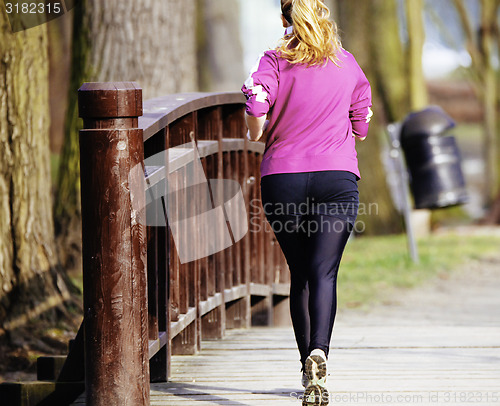 Image of Sized woman jogging in park