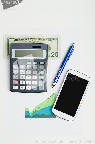 Image of USA dollar money banknotes, calculator and mobile phone