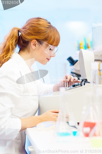 Image of Attractive young scientist pipetting.