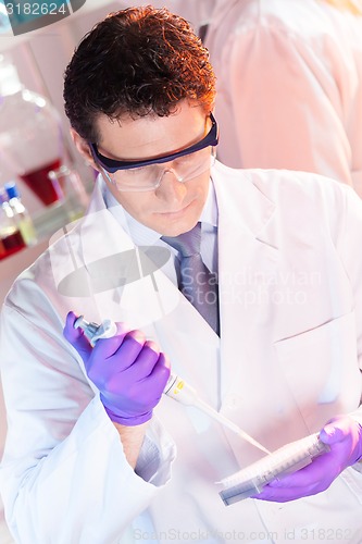 Image of Researcher pipetting in laboratory.