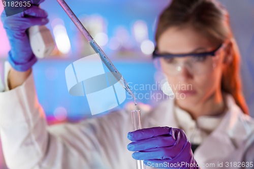 Image of Attractive young scientist pipetting.