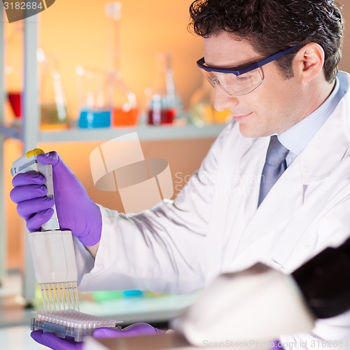 Image of Researcher pipetting in laboratory.