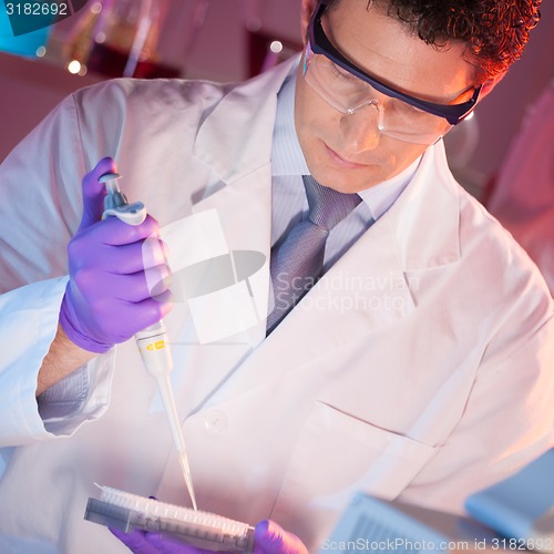 Image of Researcher pipetting in laboratory.