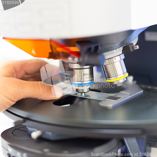 Image of Scientist microscoping on fluorescent microscope. 