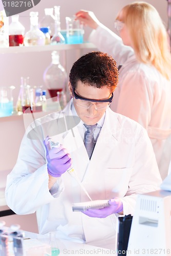 Image of Researcher pipetting in laboratory.