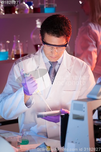 Image of Researcher pipetting in laboratory.