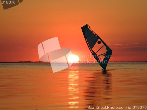 Image of Silhouette of a windsurfer on waves of a gulf on a sunset 1