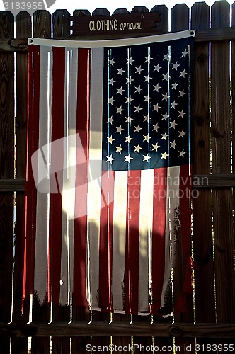 Image of tattered american flag on fence