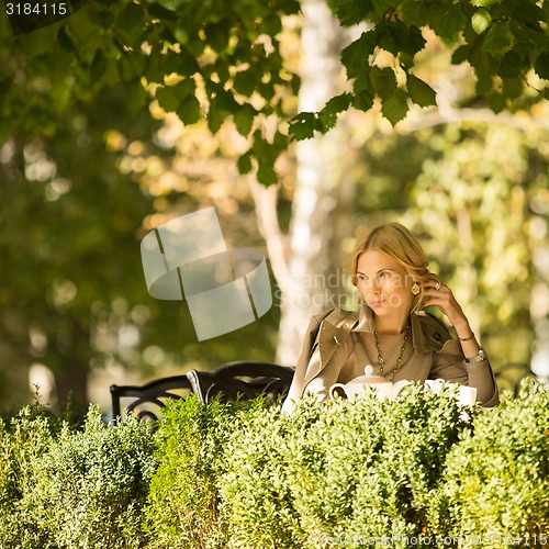 Image of portrait of a beautiful young woman in park.