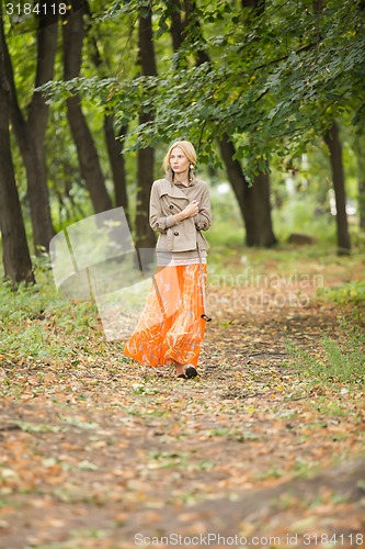 Image of Young woman walking in forest