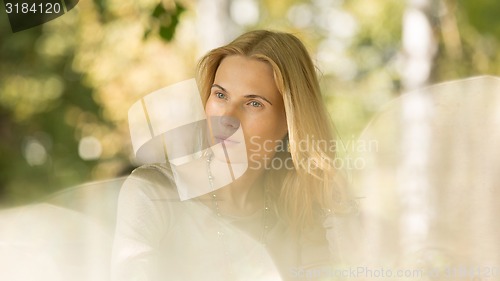 Image of portrait of a beautiful young woman in park.