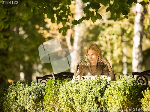 Image of portrait of a beautiful young woman in park.