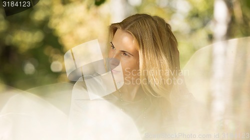 Image of portrait of a beautiful young woman in park.