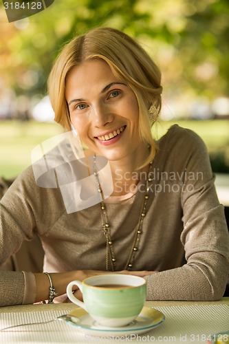 Image of portrait of a beautiful young woman in park.