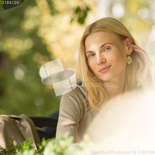 Image of portrait of a beautiful young woman in park.