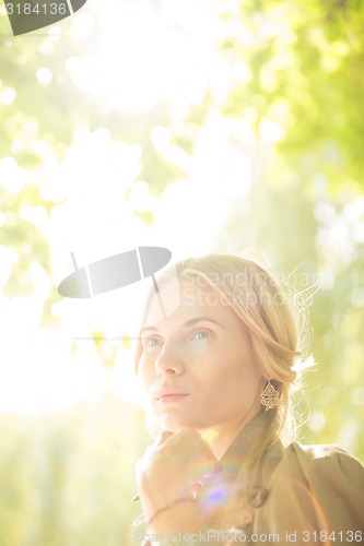 Image of portrait of a beautiful young woman in park.