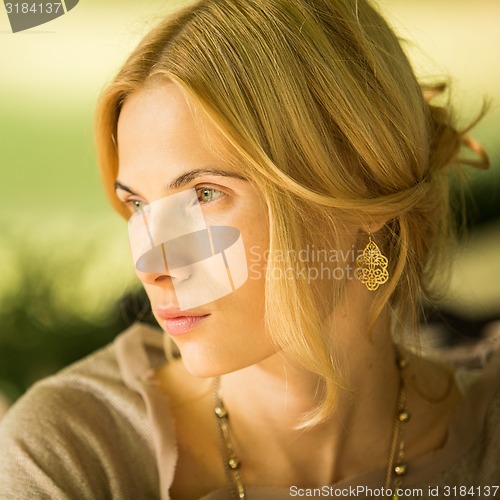 Image of portrait of a beautiful young woman in park.