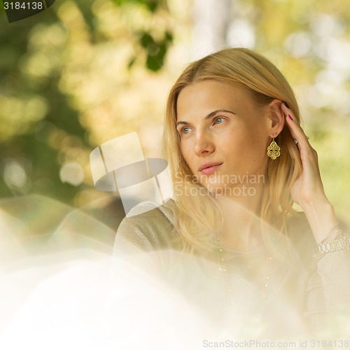 Image of portrait of a beautiful young woman in park.