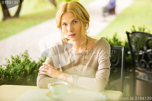 Image of portrait of a beautiful young woman in park.