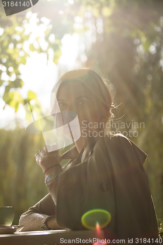 Image of portrait of a beautiful young woman in park.