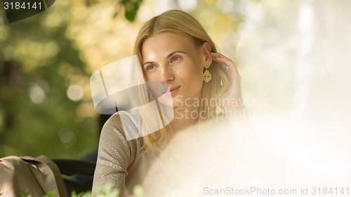 Image of portrait of a beautiful young woman in park.