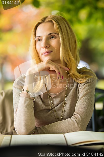 Image of portrait of a beautiful young woman in park.
