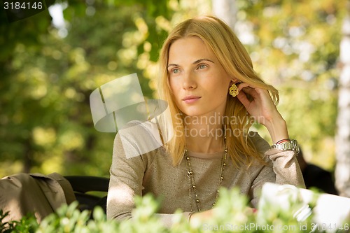 Image of portrait of a beautiful young woman in park.