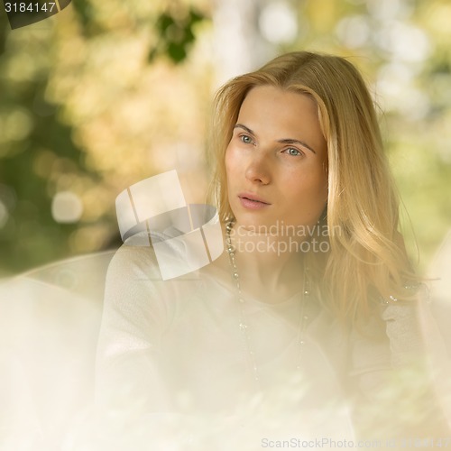 Image of portrait of a beautiful young woman in park.