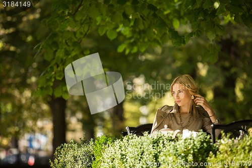 Image of portrait of a beautiful young woman in park.