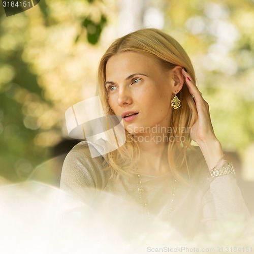 Image of portrait of a beautiful young woman in park.