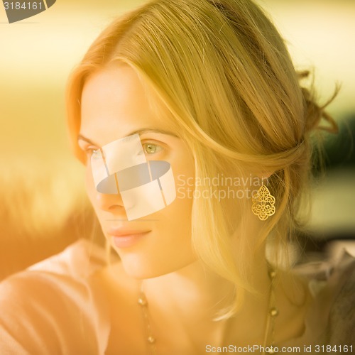 Image of portrait of a beautiful young woman in park.