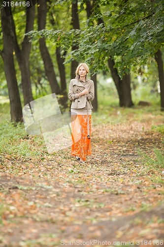 Image of Young woman walking in forest