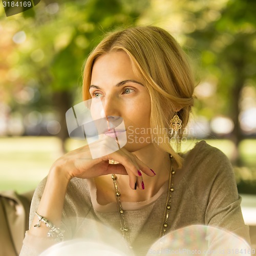 Image of portrait of a beautiful young woman in park.