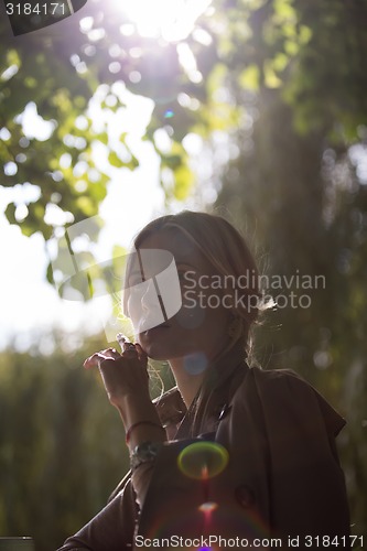 Image of portrait of a beautiful young woman in park.