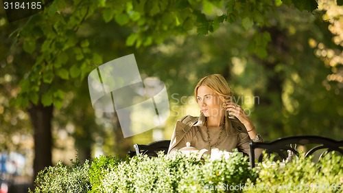 Image of portrait of a beautiful young woman in park.