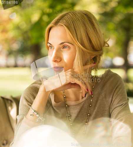 Image of portrait of a beautiful young woman in park.