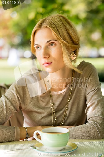 Image of portrait of a beautiful young woman in park.