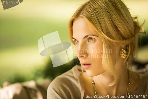 Image of portrait of a beautiful young woman in park.
